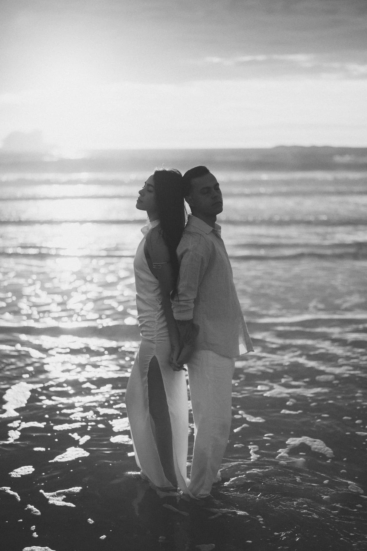 Talita e Matheus juntos diante do mar, em preto e branco
